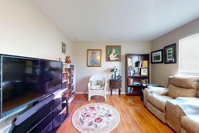 living area with baseboards and light wood-type flooring