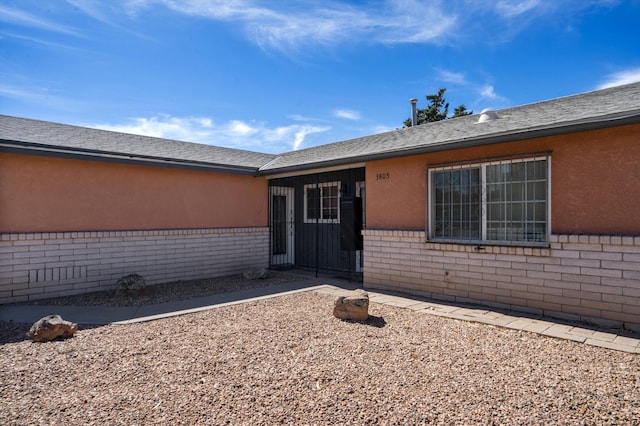 entrance to property with stucco siding and brick siding