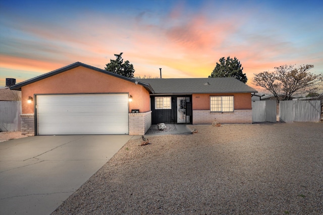 ranch-style home with brick siding, driveway, a garage, and fence