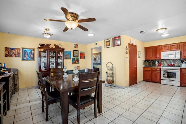 dining room featuring light tile patterned floors, visible vents, a ceiling fan, and a toaster