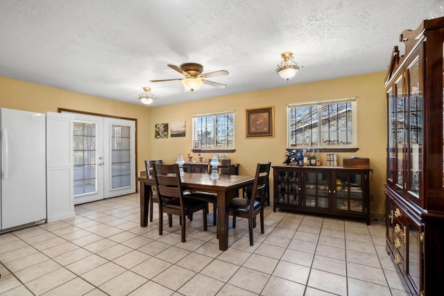 dining room with light tile patterned floors, french doors, a textured ceiling, and ceiling fan