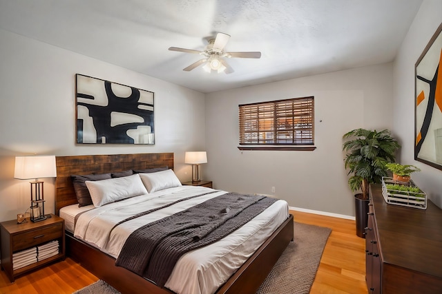 bedroom featuring light wood-style flooring, baseboards, and ceiling fan