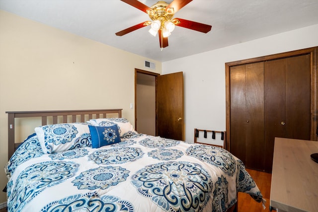 bedroom featuring wood finished floors, visible vents, a closet, and ceiling fan