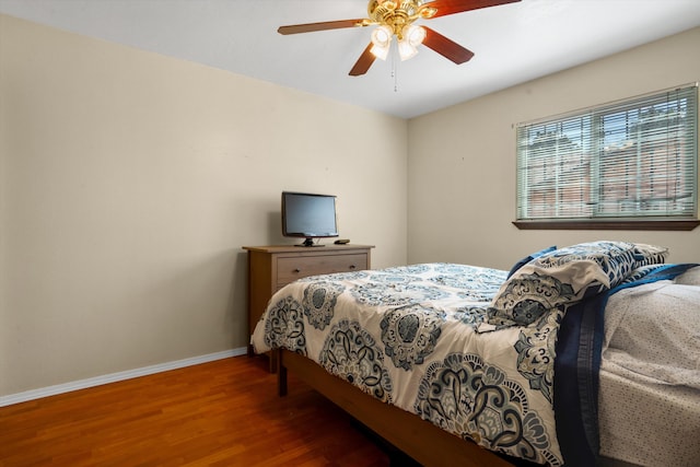 bedroom with ceiling fan, baseboards, and wood finished floors