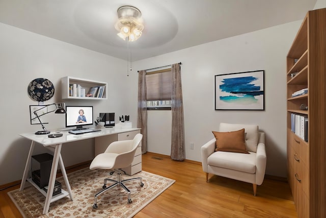 home office featuring ceiling fan, baseboards, and light wood-style floors