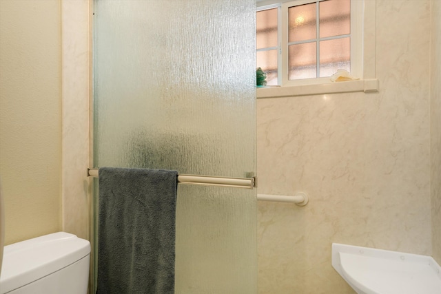 bathroom with toilet and a textured wall