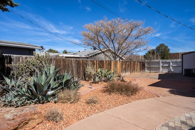 view of yard featuring central AC unit, a fenced backyard, and a patio area