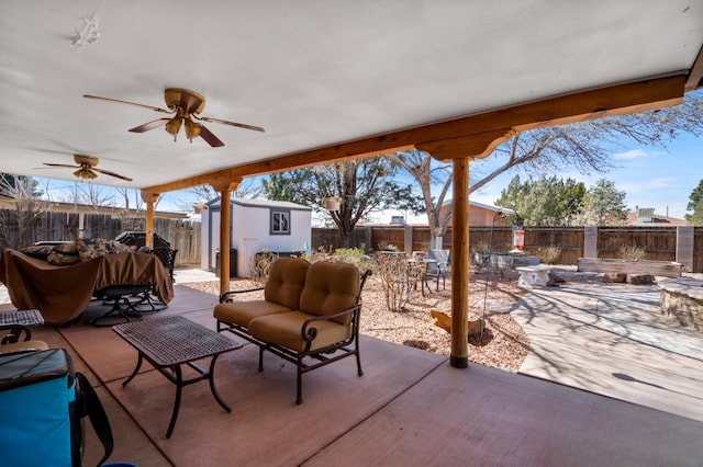 view of patio / terrace featuring outdoor dining space, a fenced backyard, a shed, an outdoor structure, and ceiling fan