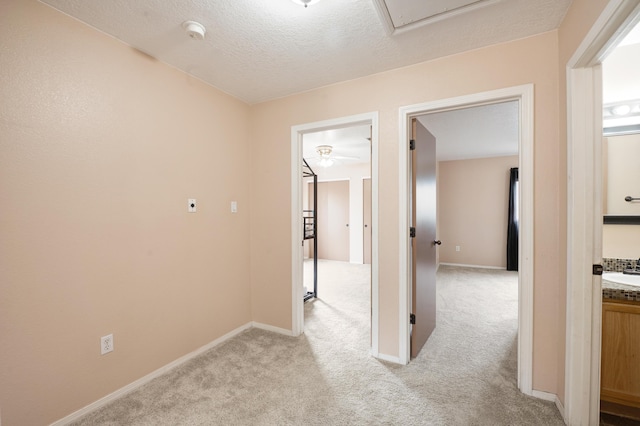 101 Colinas Ave NE, Albuquerque, NM 87113 - hall featuring a textured ceiling, a sink, baseboards, and light carpet