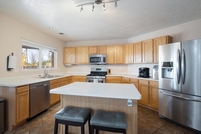 101 Colinas Ave NE, Albuquerque, NM 87113 - kitchen with a kitchen bar, visible vents, a sink, stainless steel appliances, and light countertops