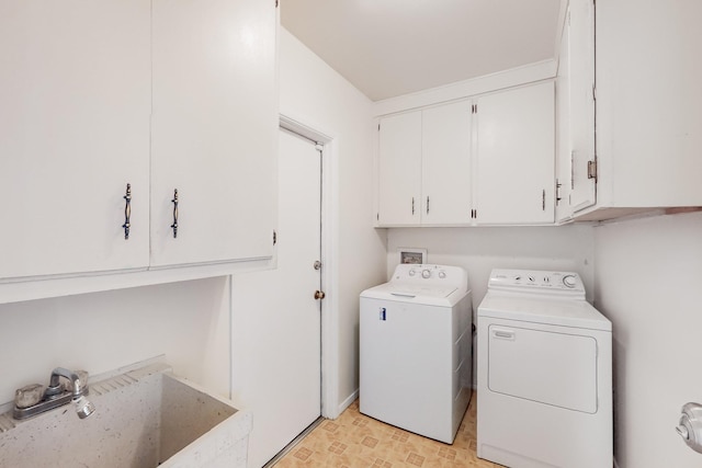 clothes washing area with cabinet space, washing machine and dryer, and a sink