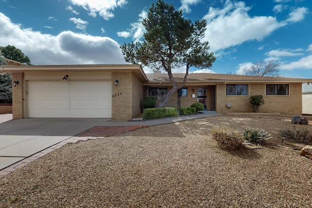 single story home featuring brick siding, an attached garage, and concrete driveway