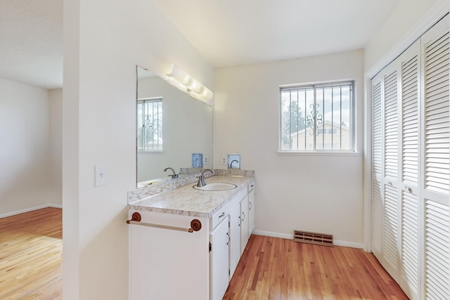 bathroom featuring vanity, wood finished floors, visible vents, and baseboards