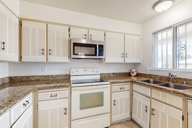 kitchen with a sink, stainless steel microwave, white cabinetry, and white range with electric cooktop