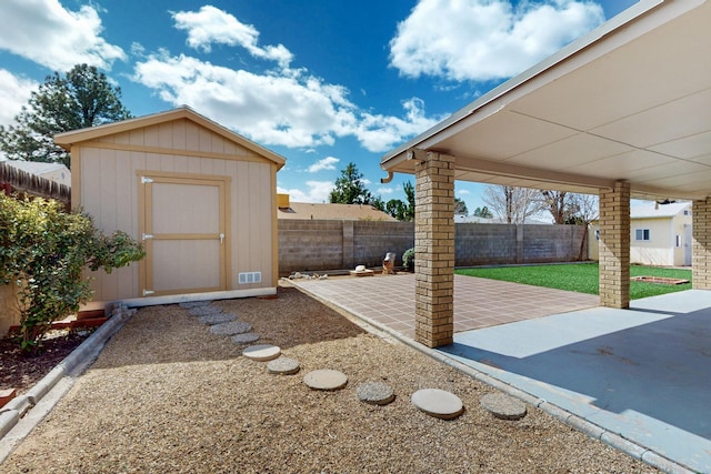 view of yard with a patio area, a shed, a fenced backyard, and an outdoor structure