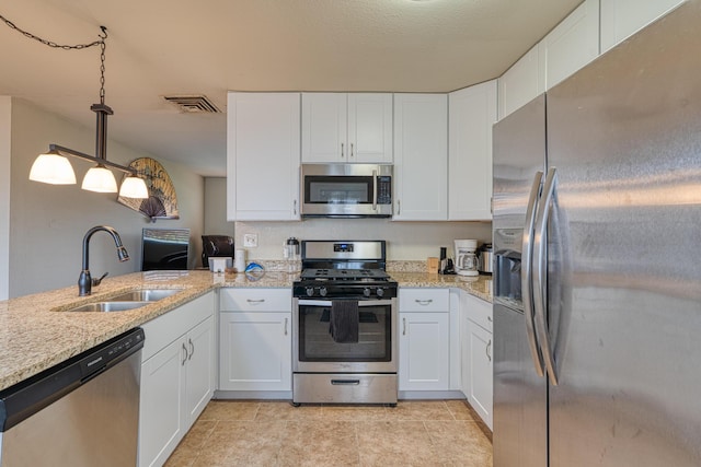 kitchen with a sink, visible vents, appliances with stainless steel finishes, and white cabinets