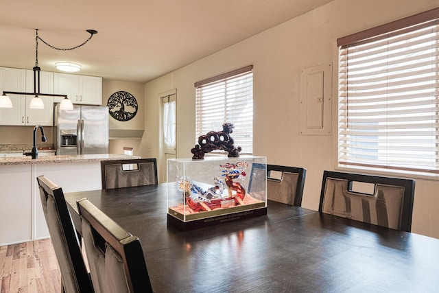 dining room with electric panel and light wood-style flooring