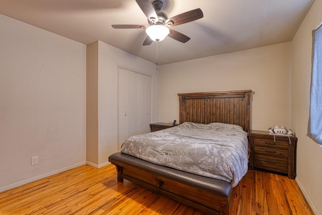 bedroom featuring light wood finished floors, ceiling fan, a closet, and baseboards