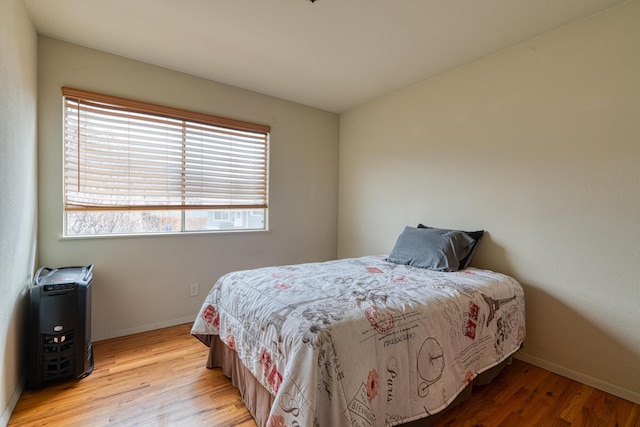 bedroom featuring light wood finished floors and baseboards