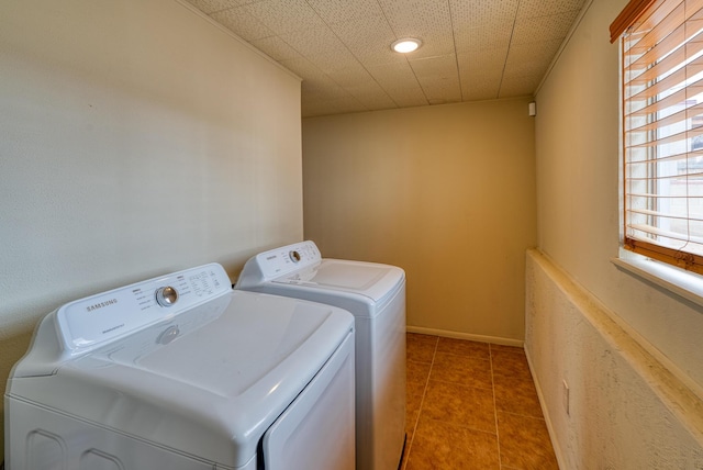 clothes washing area with light tile patterned floors, laundry area, independent washer and dryer, and baseboards