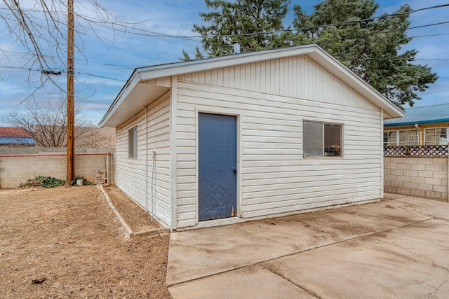 view of outbuilding featuring fence