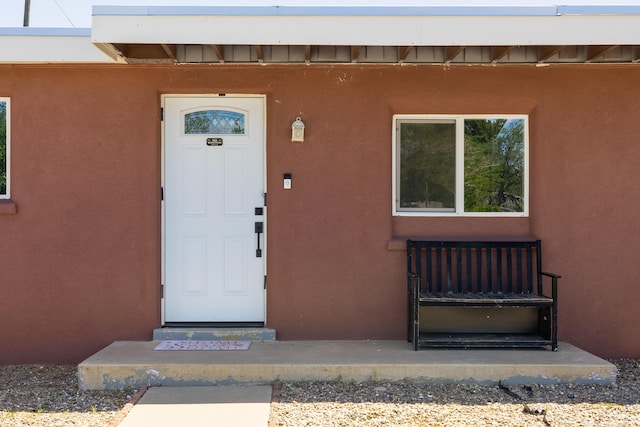doorway to property featuring stucco siding