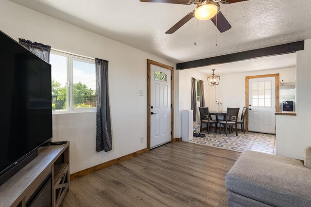 living room with baseboards, a ceiling fan, and wood finished floors