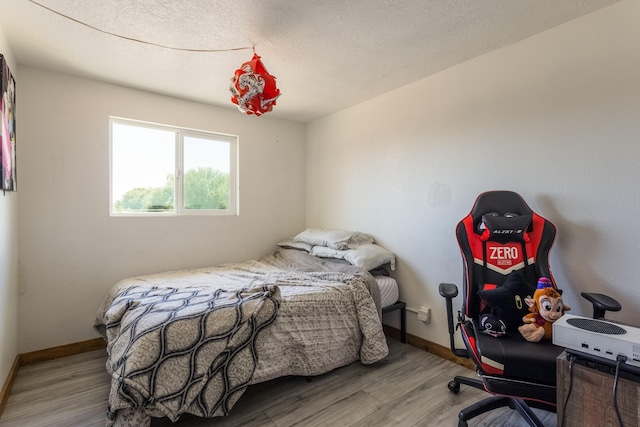 bedroom with baseboards and wood finished floors