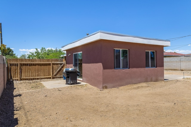 view of side of property with a fenced backyard and stucco siding