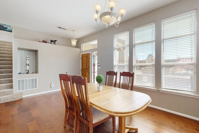 1001 Calle Garza NE, Albuquerque, NM 87113 - dining area with stairs, an inviting chandelier, visible vents, and hardwood / wood-style floors