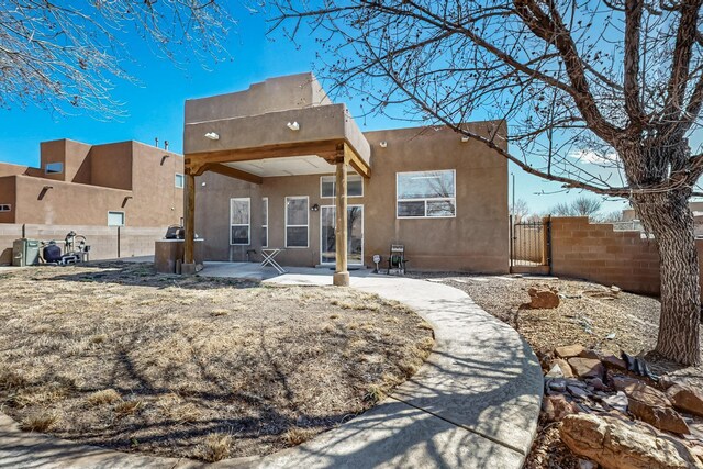 1001 Calle Garza NE, Albuquerque, NM 87113 - back of property featuring stucco siding, fence, a patio, and a gate