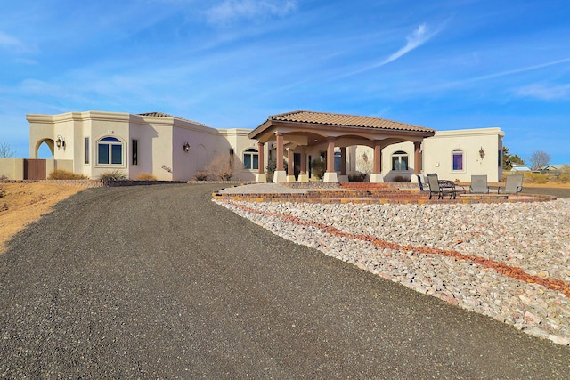 901 12th Ave SE, Rio Rancho, NM 87124 - view of front of house with stucco siding, a tile roof, and a patio