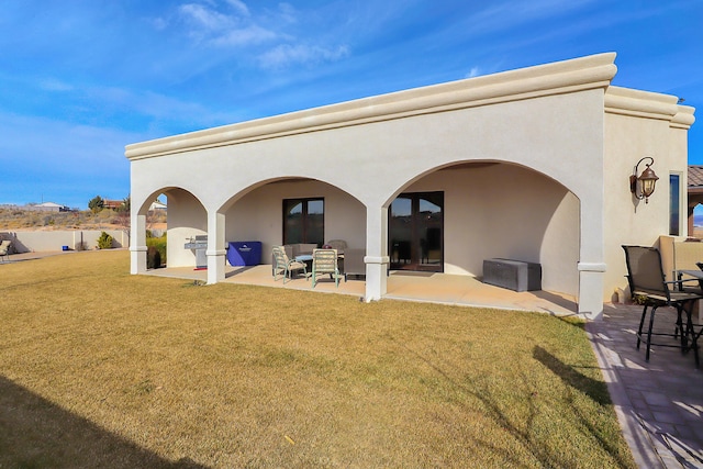 901 12th Ave SE, Rio Rancho, NM 87124 - back of property with stucco siding, a patio, and a yard