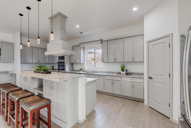 2006 Suttle Ct NE, Rio Rancho, NM 87124 - kitchen featuring gray cabinetry, a center island with sink, a sink, island exhaust hood, and appliances with stainless steel finishes