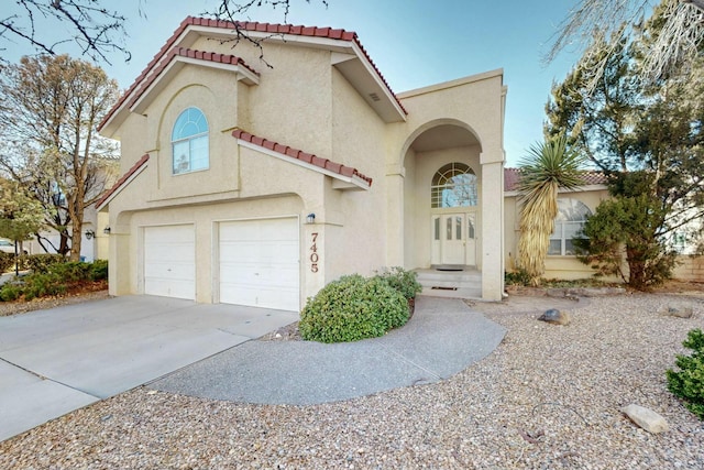 mediterranean / spanish-style home with stucco siding, driveway, and a tiled roof