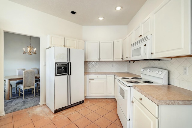 kitchen featuring an inviting chandelier, white appliances, light tile patterned floors, and light countertops