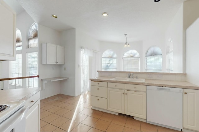 kitchen featuring a sink, dishwasher, white cabinets, and light tile patterned flooring