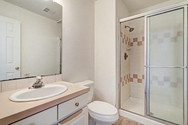 full bathroom with vanity, a shower stall, toilet, and visible vents