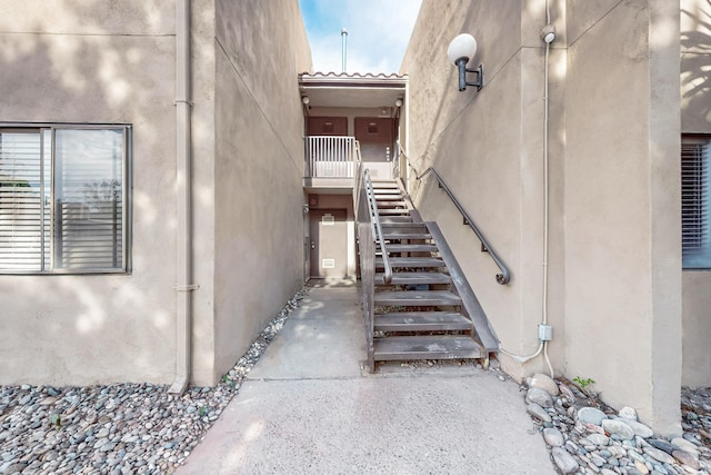 view of side of home featuring stairs and stucco siding