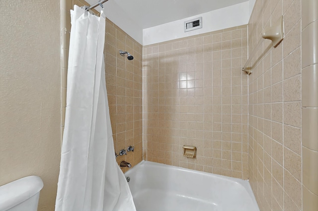 bathroom featuring shower / bathtub combination with curtain, toilet, and visible vents