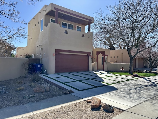 2638 Aloysia Ln NW, Albuquerque, NM 87104 - pueblo-style home with stucco siding, an attached garage, and fence