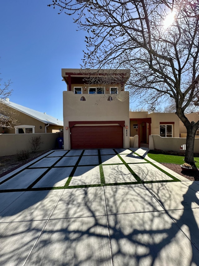 2638 Aloysia Ln NW, Albuquerque, NM 87104 - view of front facade with concrete driveway, an attached garage, fence, and stucco siding