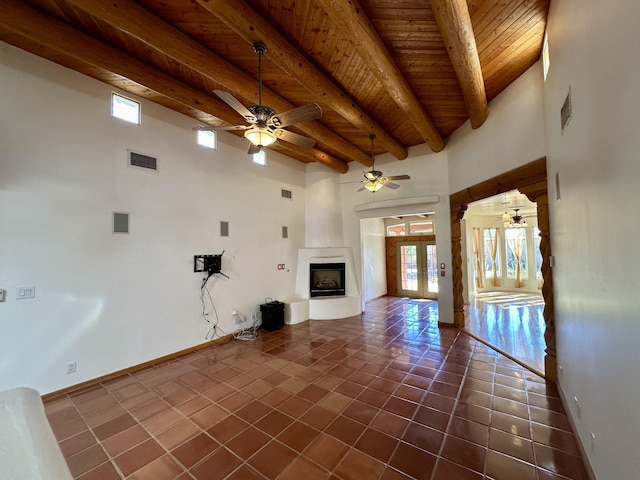 2638 Aloysia Ln NW, Albuquerque, NM 87104 - unfurnished living room with visible vents, ceiling fan, beamed ceiling, dark tile patterned floors, and a large fireplace