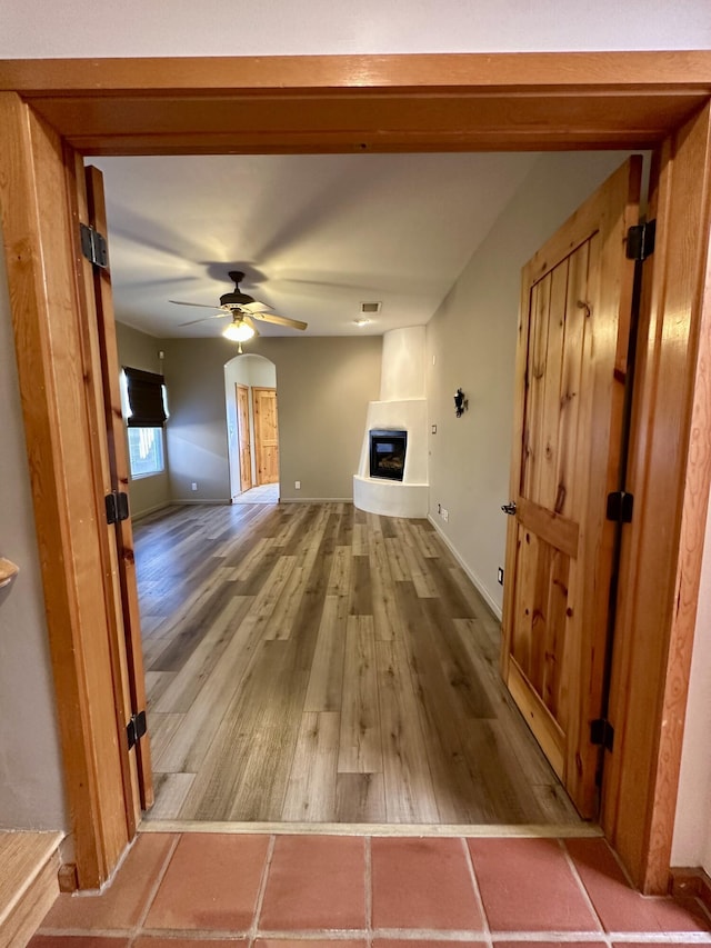 2638 Aloysia Ln NW, Albuquerque, NM 87104 - unfurnished living room featuring visible vents, baseboards, a fireplace, wood finished floors, and a ceiling fan