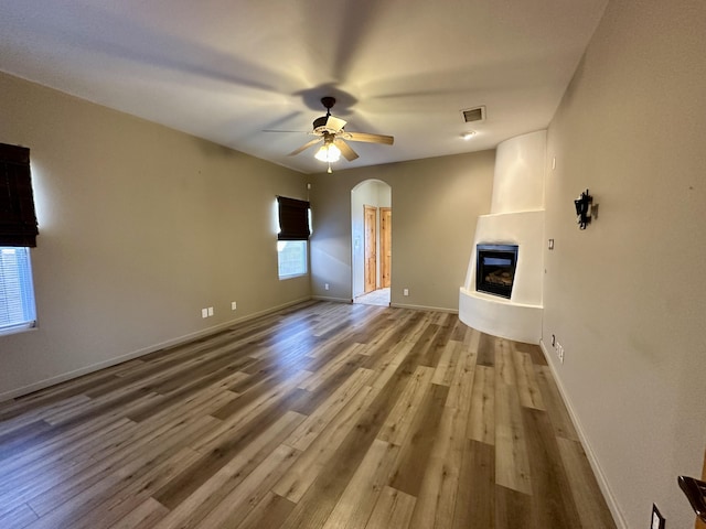 2638 Aloysia Ln NW, Albuquerque, NM 87104 - unfurnished living room featuring visible vents, wood finished floors, a fireplace, baseboards, and ceiling fan