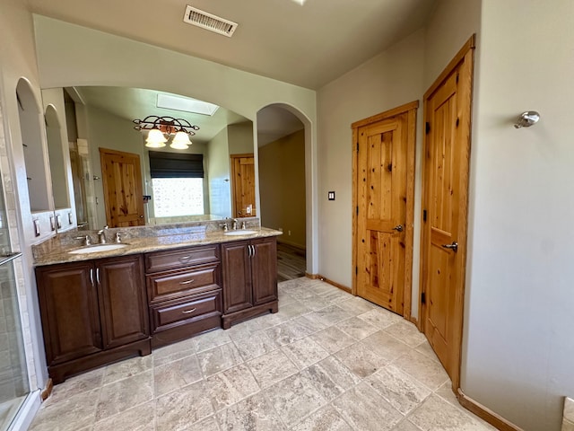 2638 Aloysia Ln NW, Albuquerque, NM 87104 - full bathroom featuring double vanity, baseboards, visible vents, and a sink