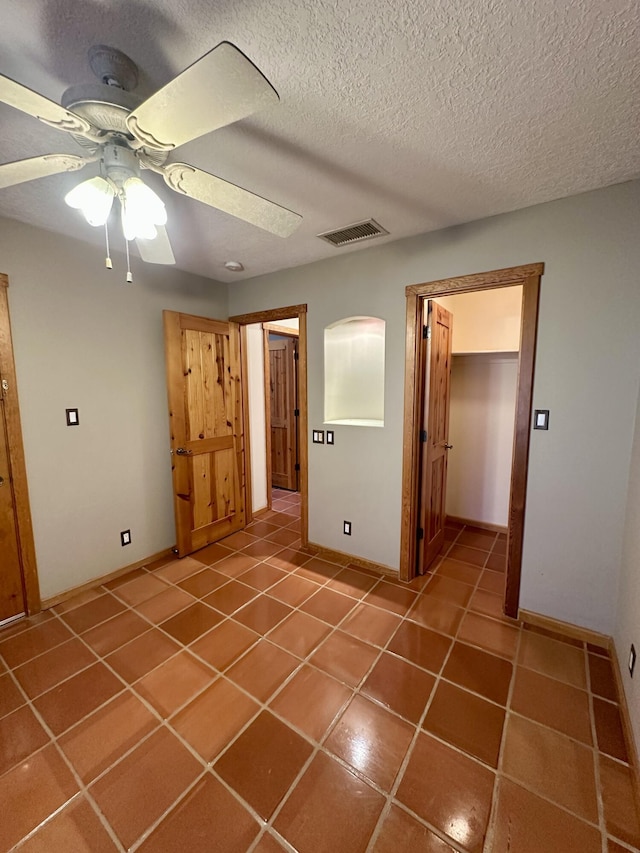 2638 Aloysia Ln NW, Albuquerque, NM 87104 - unfurnished bedroom with tile patterned flooring, visible vents, a closet, a textured ceiling, and a ceiling fan