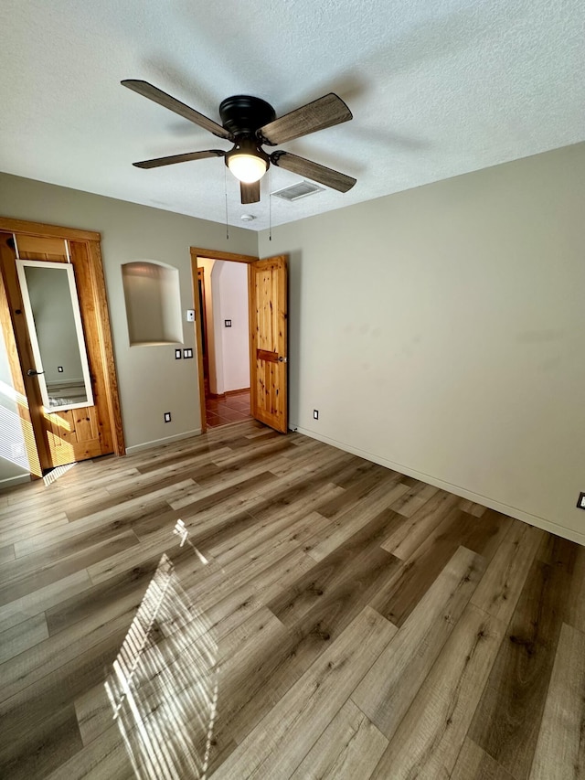 2638 Aloysia Ln NW, Albuquerque, NM 87104 - unfurnished bedroom featuring ceiling fan, visible vents, a textured ceiling, and wood finished floors