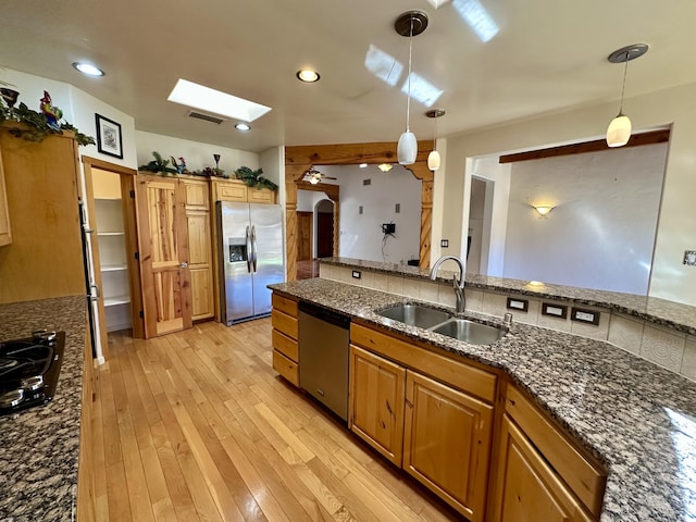 2638 Aloysia Ln NW, Albuquerque, NM 87104 - kitchen with visible vents, light wood-style flooring, a skylight, stainless steel appliances, and a sink
