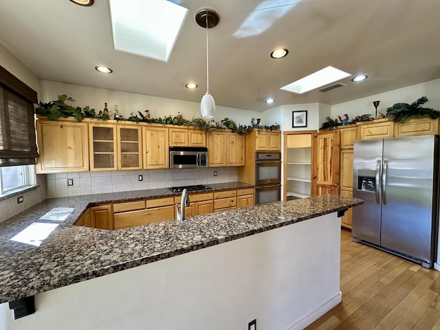 2638 Aloysia Ln NW, Albuquerque, NM 87104 - kitchen with glass insert cabinets, light wood-type flooring, a peninsula, a skylight, and stainless steel appliances